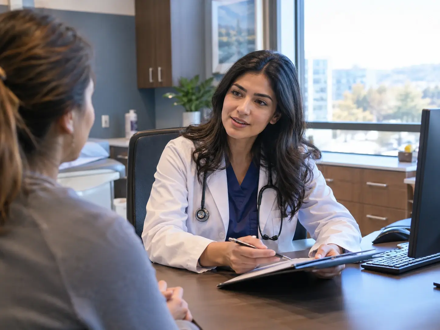 Primary care physician reviewing a tablet with a patient during a consultation